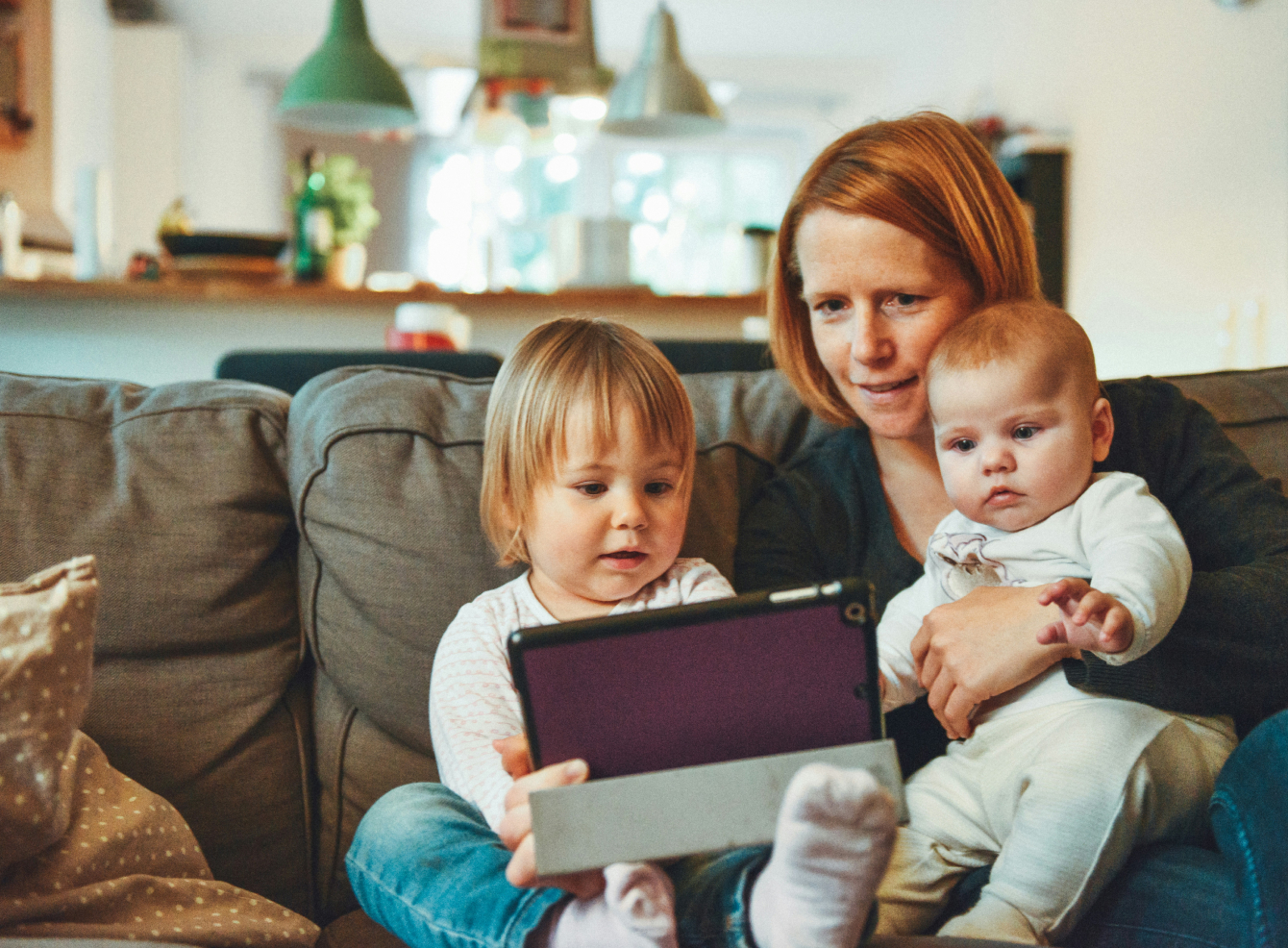 Mom sitting with her kids on sofa